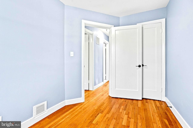 unfurnished bedroom featuring light hardwood / wood-style floors and a closet