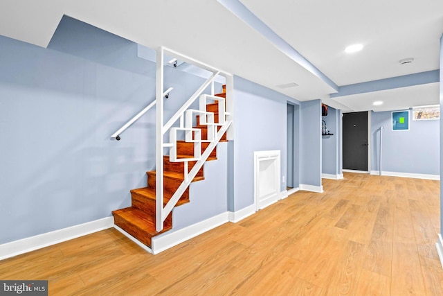 staircase with hardwood / wood-style floors