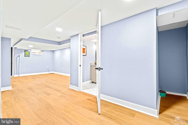 basement with light hardwood / wood-style flooring