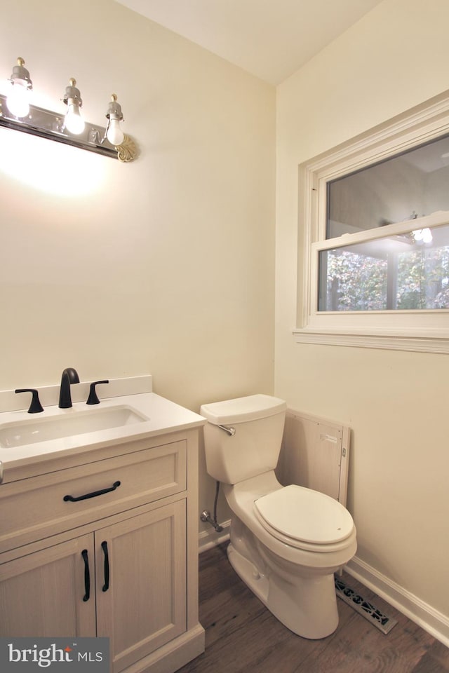 bathroom featuring vanity, hardwood / wood-style flooring, and toilet