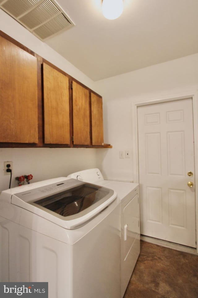 laundry area featuring washing machine and dryer and cabinets