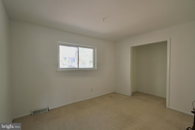 unfurnished room featuring light carpet