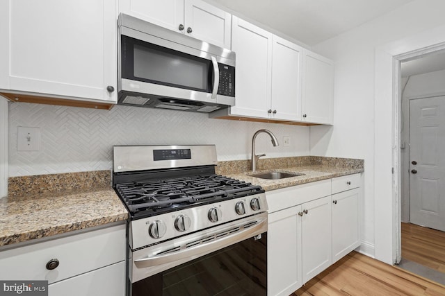 kitchen featuring light hardwood / wood-style floors, sink, white cabinetry, and stainless steel appliances