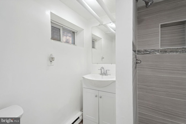 bathroom featuring vanity, toilet, and tiled shower