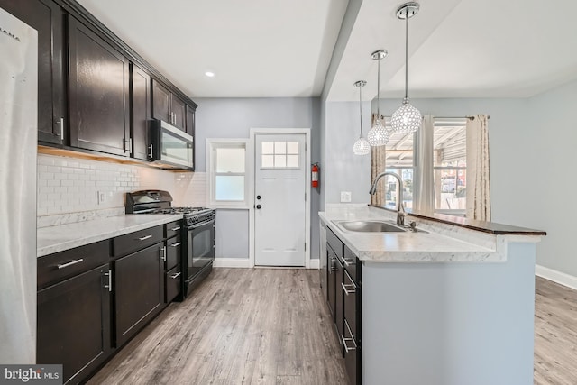 kitchen with plenty of natural light, sink, black range with gas stovetop, and light hardwood / wood-style flooring