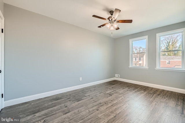 empty room with ceiling fan and dark hardwood / wood-style floors