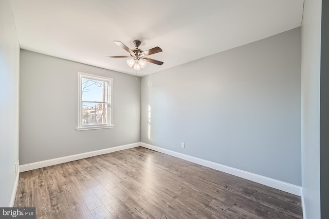 empty room featuring dark wood-type flooring and ceiling fan