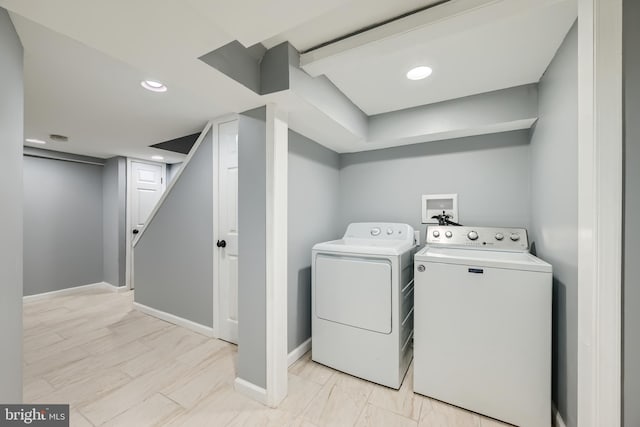 clothes washing area with washer and clothes dryer