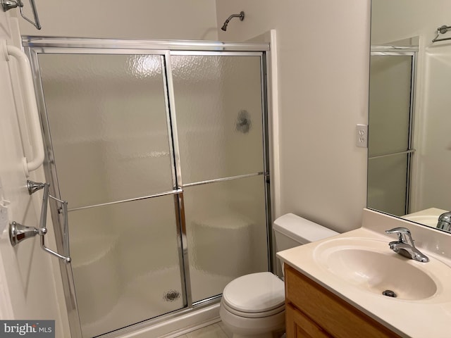 bathroom featuring tile patterned floors, vanity, toilet, and an enclosed shower