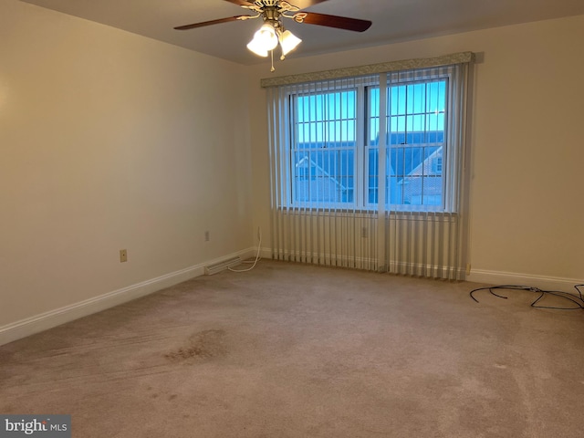 empty room featuring light colored carpet and ceiling fan