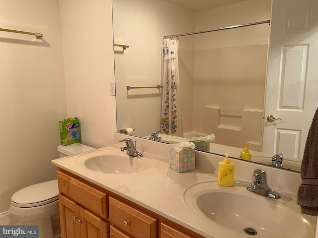 bathroom featuring toilet, vanity, and walk in shower