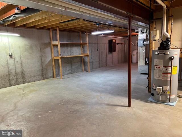 basement featuring electric panel and gas water heater