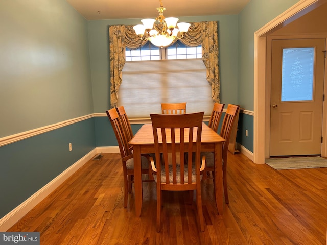 dining room featuring wood-type flooring and a chandelier