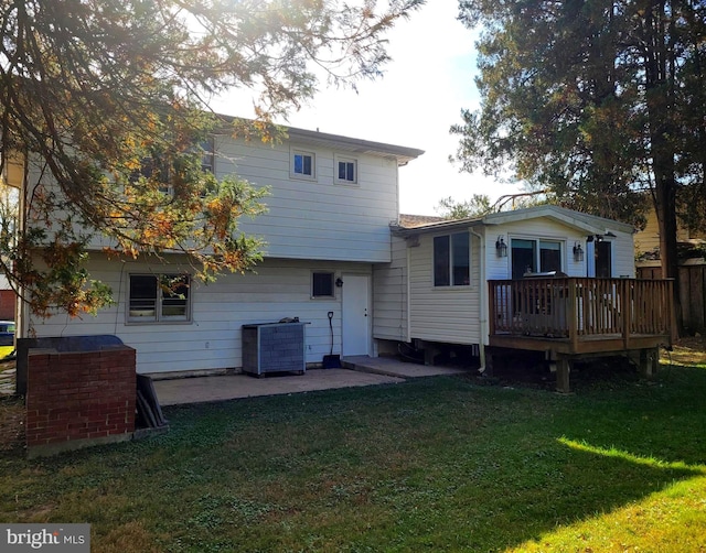 rear view of house with a patio area, a wooden deck, cooling unit, and a lawn