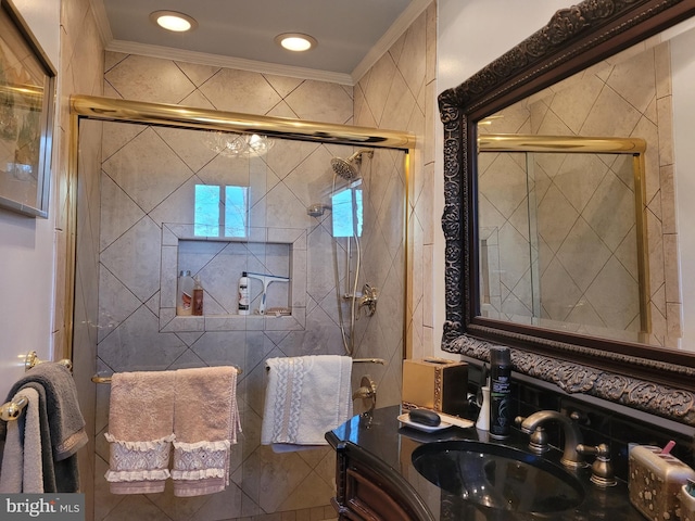 bathroom featuring a shower with door, ornamental molding, and sink