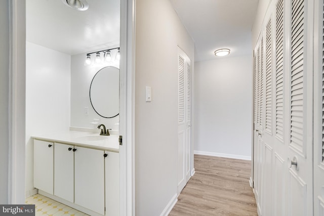 hallway with sink and light hardwood / wood-style flooring