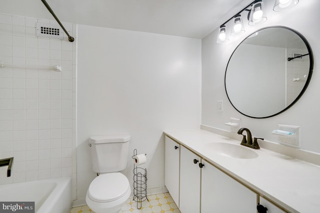 full bathroom featuring vanity, tiled shower / bath combo, and toilet