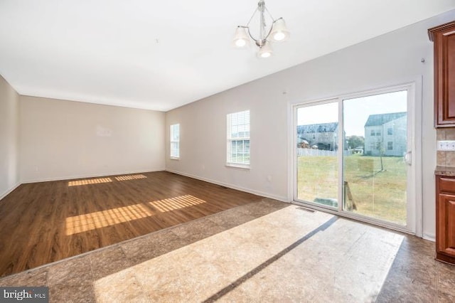 unfurnished room featuring dark hardwood / wood-style floors and an inviting chandelier