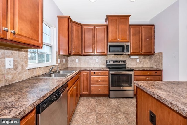 kitchen with backsplash, sink, and appliances with stainless steel finishes