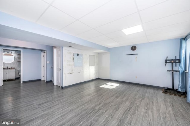 interior space featuring a paneled ceiling and dark hardwood / wood-style floors