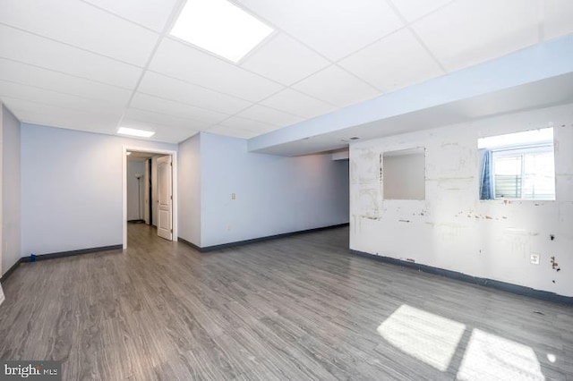 basement featuring a drop ceiling and wood-type flooring