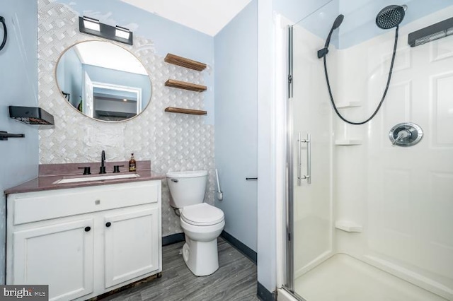 bathroom featuring hardwood / wood-style floors, vanity, toilet, and an enclosed shower