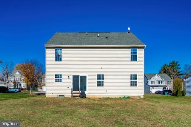 rear view of house featuring a yard