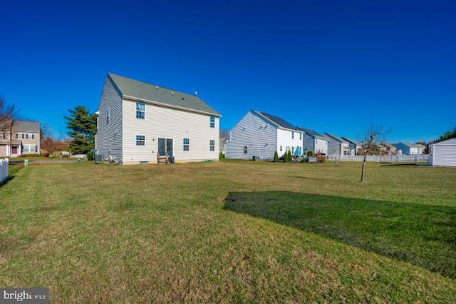 rear view of house featuring a yard