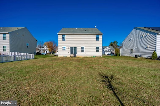 back of house featuring central air condition unit and a yard