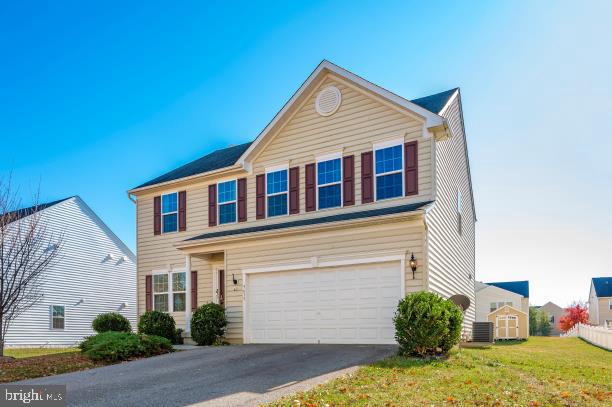 view of front of property featuring central AC unit and a garage