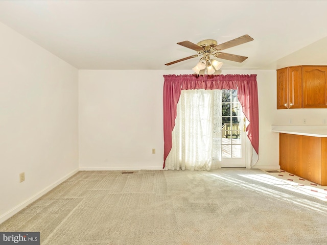 carpeted spare room with ceiling fan