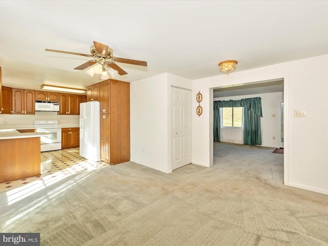 kitchen featuring light carpet, white appliances, and ceiling fan