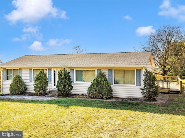 single story home with a wooden deck and a front yard