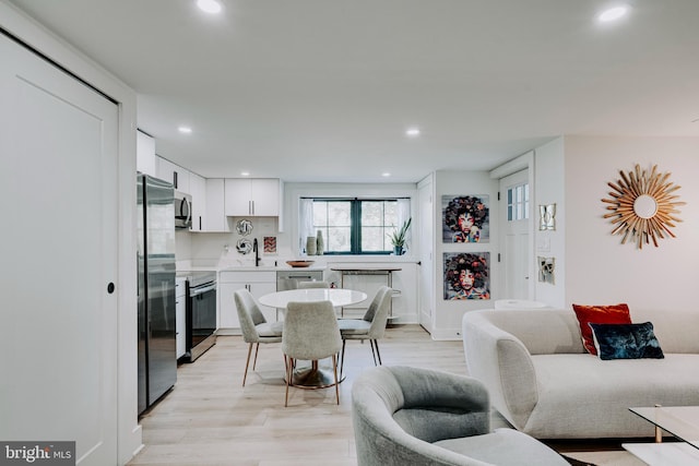 dining room featuring sink and light hardwood / wood-style flooring