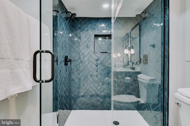 bathroom with a shower with shower door and toilet