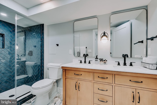 bathroom featuring toilet, vanity, and a shower with shower door