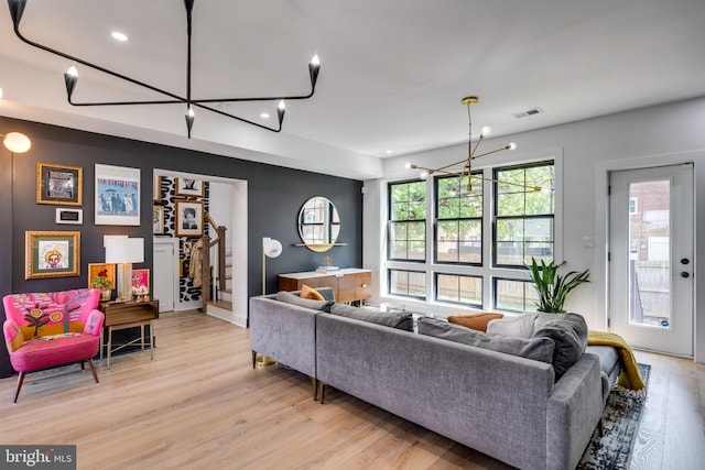 living room featuring an inviting chandelier and light hardwood / wood-style flooring