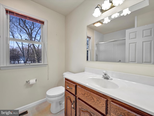 bathroom featuring tile patterned floors, vanity, toilet, a notable chandelier, and a shower with shower door