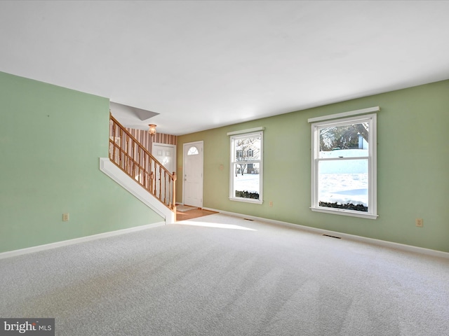 unfurnished living room featuring light carpet