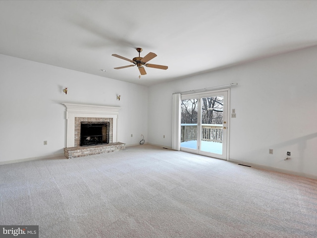 unfurnished living room featuring light carpet, ceiling fan, and a fireplace