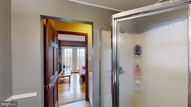 bathroom featuring walk in shower, wood-type flooring, and french doors