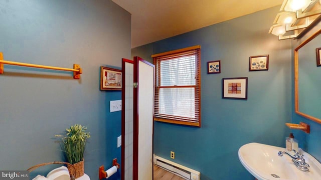 bathroom with hardwood / wood-style flooring, sink, and baseboard heating