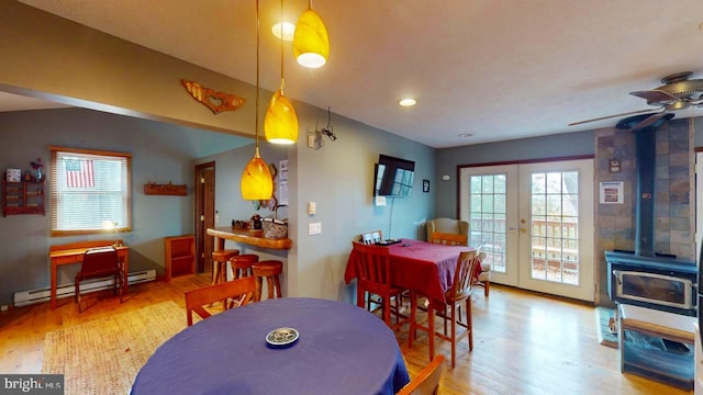 dining room featuring french doors, hardwood / wood-style flooring, a baseboard heating unit, lofted ceiling, and ceiling fan