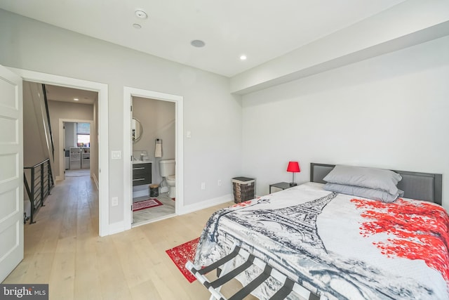 bedroom with ensuite bath and light hardwood / wood-style flooring