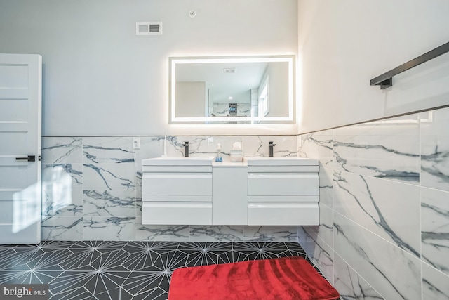 bathroom featuring vanity and tile walls