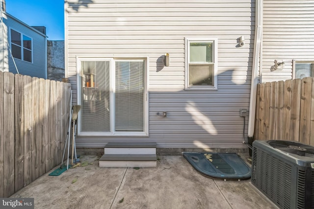 view of exterior entry with cooling unit and a patio