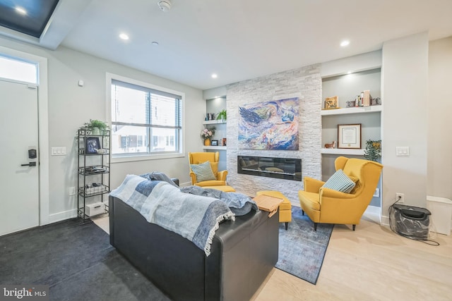 living room featuring a fireplace, hardwood / wood-style floors, and built in shelves