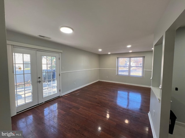 spare room with dark hardwood / wood-style flooring, plenty of natural light, and french doors