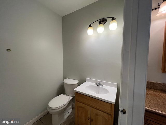 bathroom featuring tile patterned flooring, vanity, and toilet