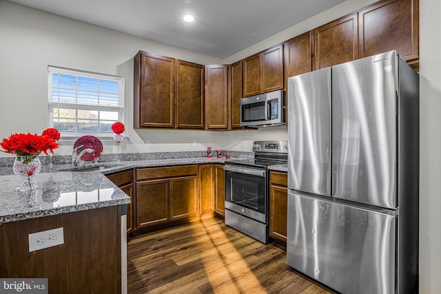 kitchen featuring dark wood-type flooring, appliances with stainless steel finishes, and stone countertops